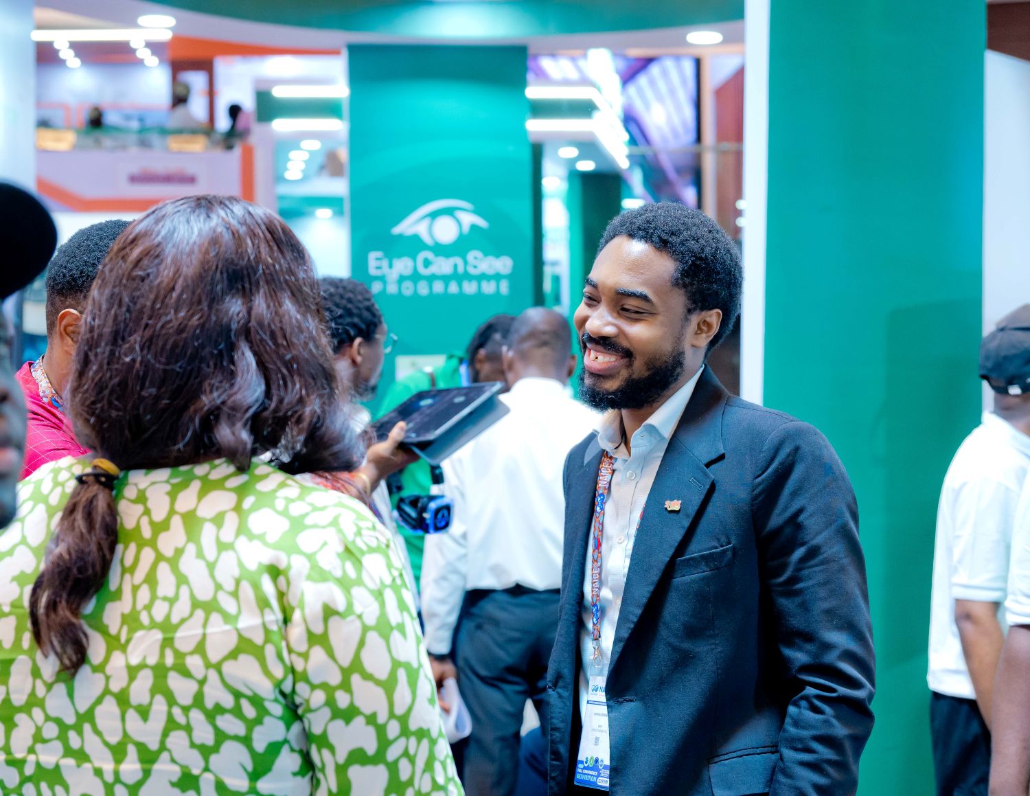 A SIGNALer smiling while talking with a visitor at the Seplat stand at NAICE 2026.